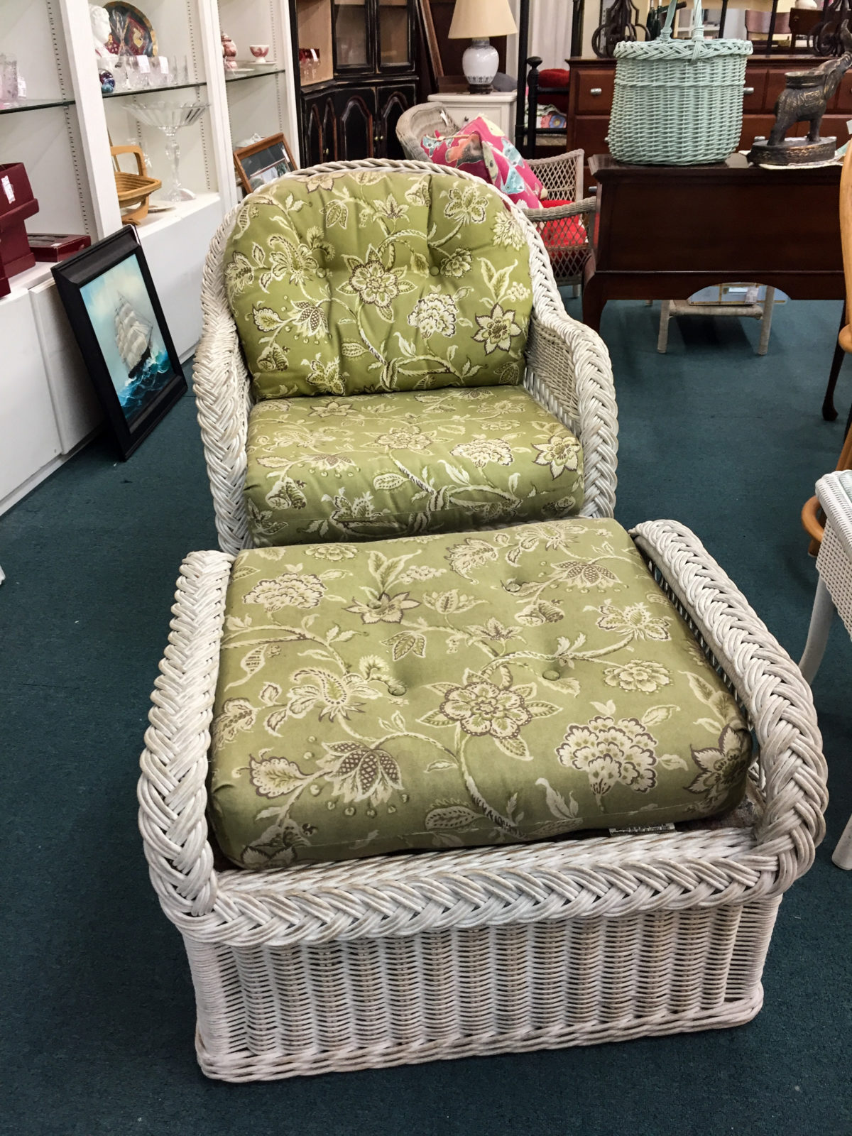 White Wicker Chair w/Ottoman • White wicker chair and white wicker ottoman. Lovely green and white flowered fabric. This piece would be a great addition to a sunroom.