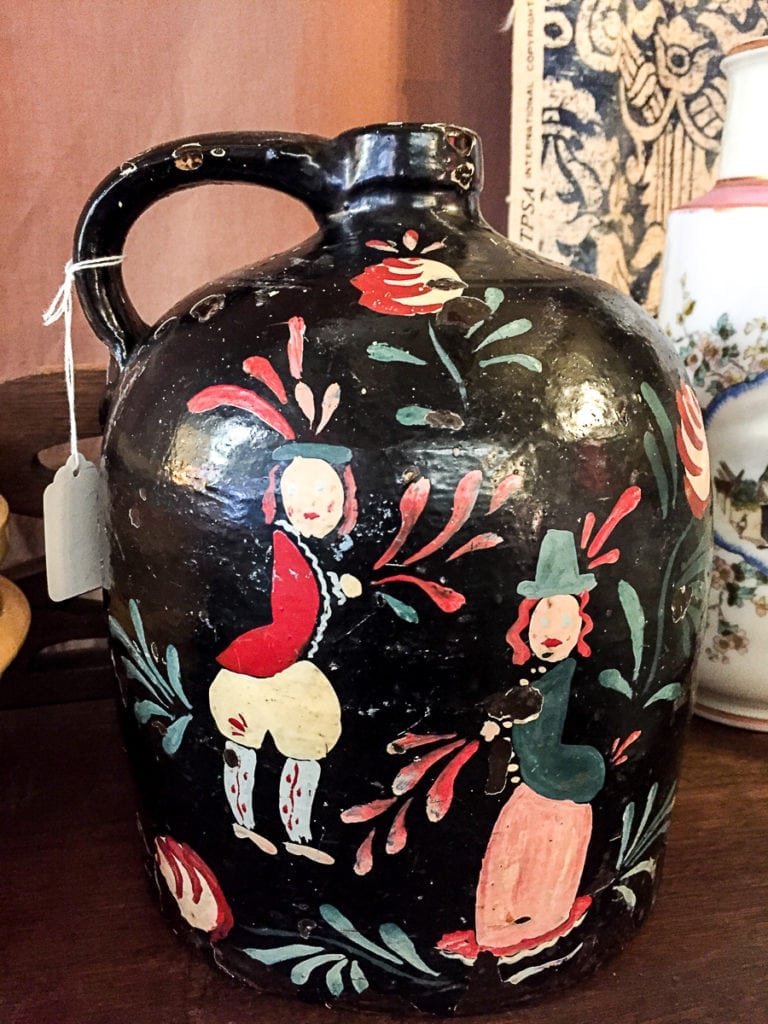 Folk Art Jug - Vintage • Vintage hand painted black folk art jug with characters. This black jug with accents of red will liven up any buffet in a dining room or give your bookshelf some pizazz. A unique item that is not found in mass market stores.