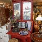 The Red Lady • A reproduction red secretary desk. This piece has been upcycled with the love and talents of our own Burke Daniel. Burke has transformed this piece with the look of a vintage piece with raised wallpaper inside, along with distressed mirrored glass.