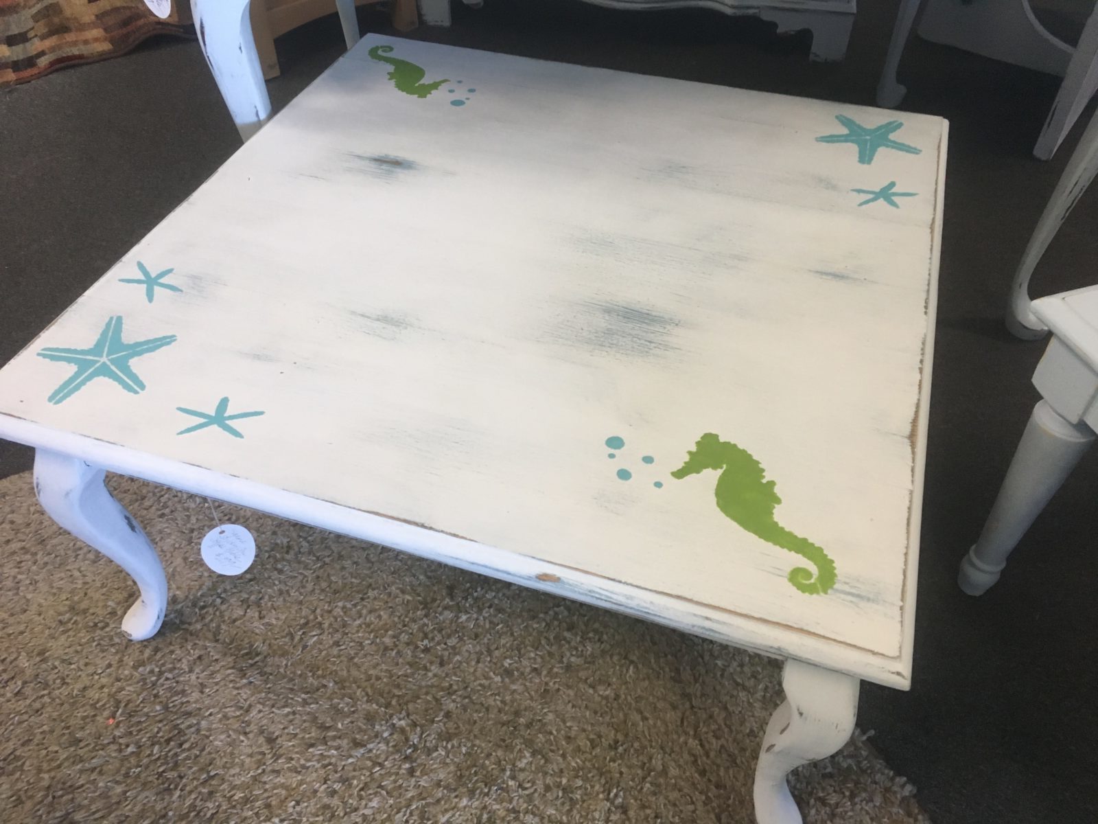 Coastal Coffee Table • What a fun and whimsical table for your beach house or family room, this square coffee table is painted with white chalk paint and lightly distressed and just for fun we've added a few starfish & seahorses!