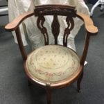 Antique Carved Chair • Antique chair with a needlepoint cushion features a carved design on the back and a very unique rounded seat. Dark wood offsets the light colored needlepoint cushion for a charming and elegant look anywhere you use this chair.
