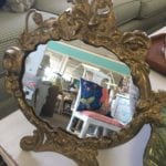 Vintage Brass Vanity Mirror • Vintage brass standing vanity mirror on easel is made of heavy brass with an attractive floral design surrounding the oval shaped mirror. Wonderful, thoughtful gift sure to add a touch of elegance to any table, vanity or bathroom.