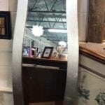 Bassett Chevel mirror • Look at those curves! This mirror would be lovely hung vertically in a dressing room or hang it horizontally over a buffet in the dining room or fireplace. Silver frame. Measures 62”x16”