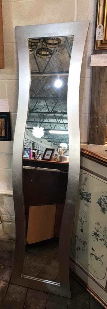 Bassett Chevel mirror • Look at those curves! This mirror would be lovely hung vertically in a dressing room or hang it horizontally over a buffet in the dining room or fireplace. Silver frame. Measures 62”x16”