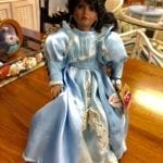 Doll with Chair • Call all doll collectors! This porcelain doll with chair is a real beauty in a light blue dress and fancy hat.